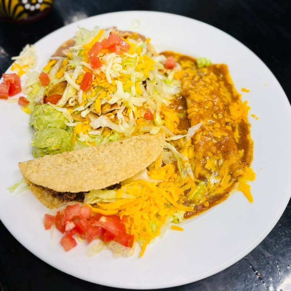 A Los Agaves Mexican Restaurant combo plate with a taco, enchilada, beans, guacamole, and salad.
